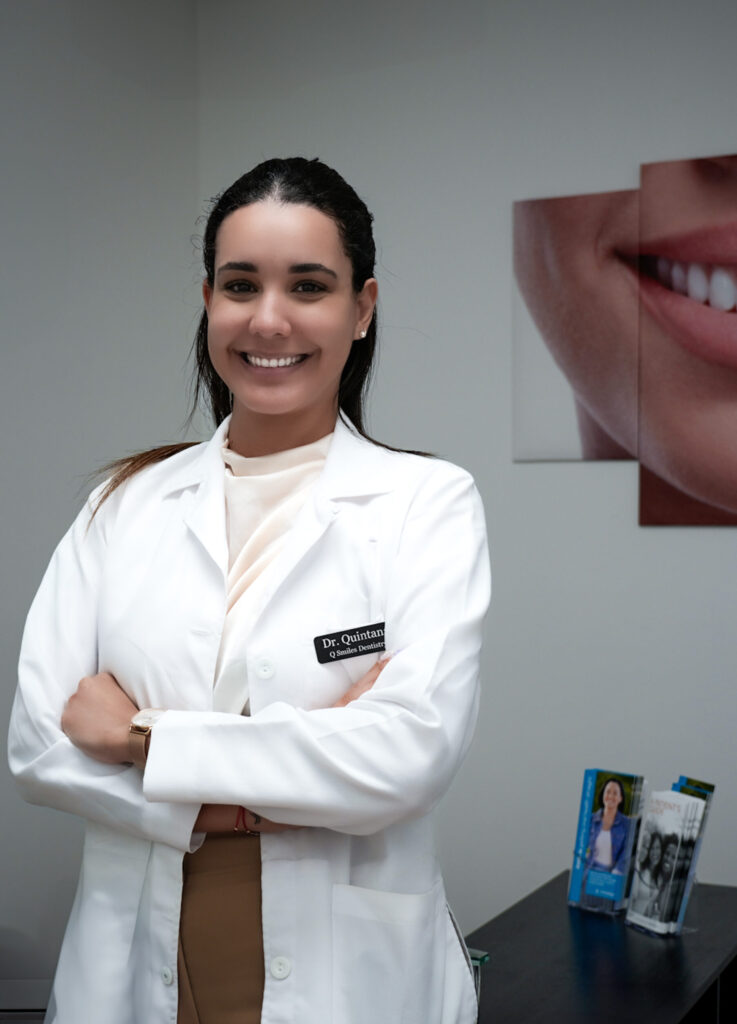 Dr. Quintana in front of poster - Q Smiles Dentistry - Implant & Cosmetic Dentistry in North Miami Beach