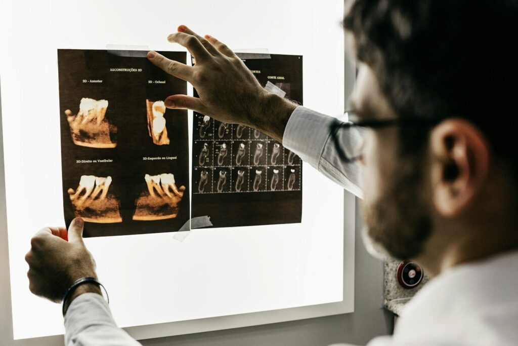 A dentist examining dental x-ray scans on a bright light box